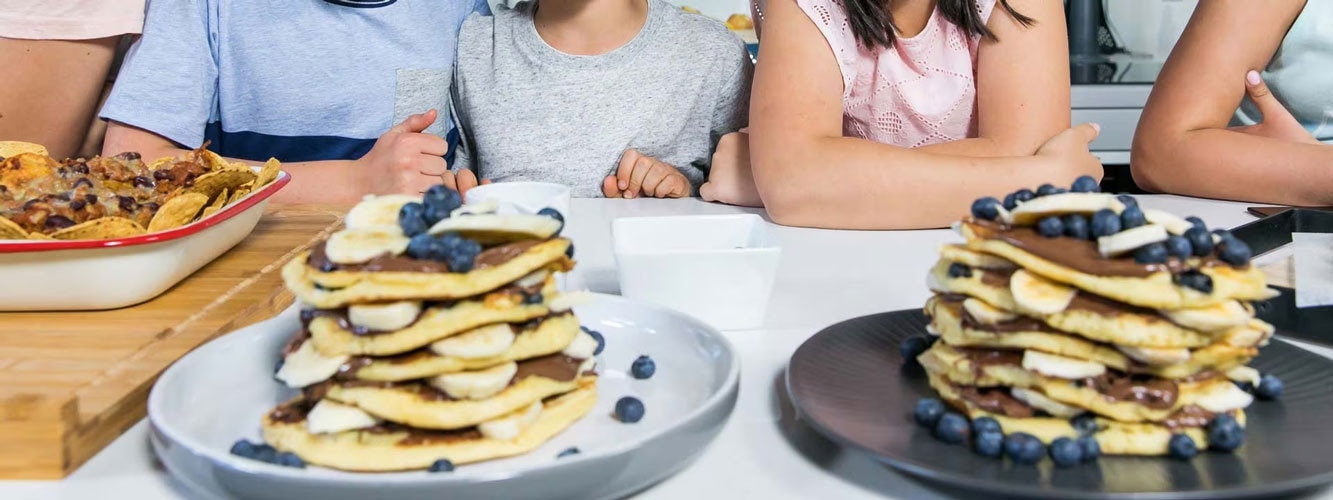 People sitting at a table with pancakes for Christmas feast